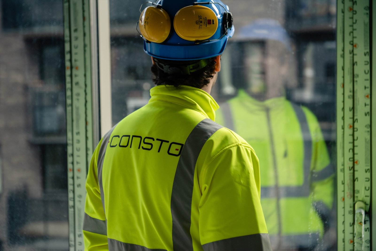 Consto-medarbeider i arbeidsjakke og hjelm på byggeplassen